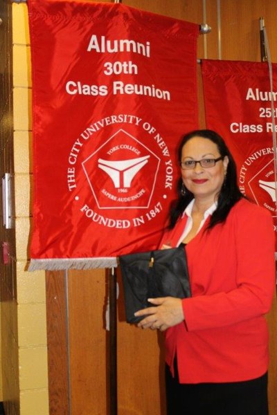 Brunilda Almodovar with her Alumni Class Reunion banner