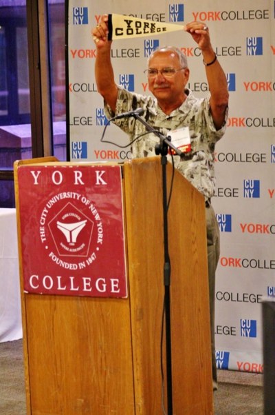 Alumni holding up his old York college banner