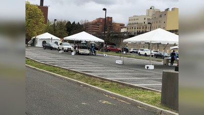 People in cars drive up to be tested for COVID-19