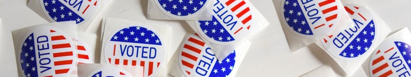 Several I voted stickers layed across the table.