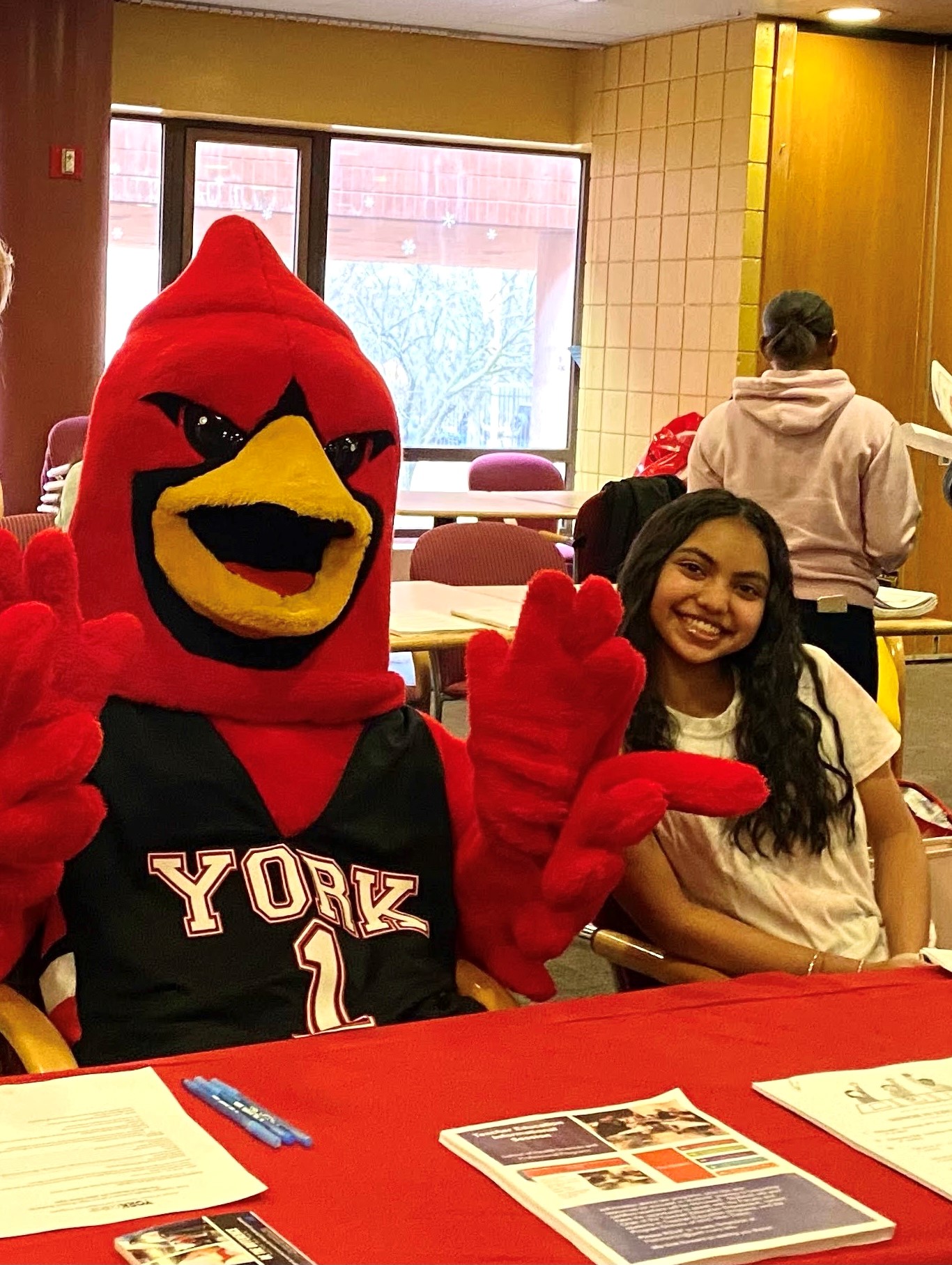 Student at an open house with mascot