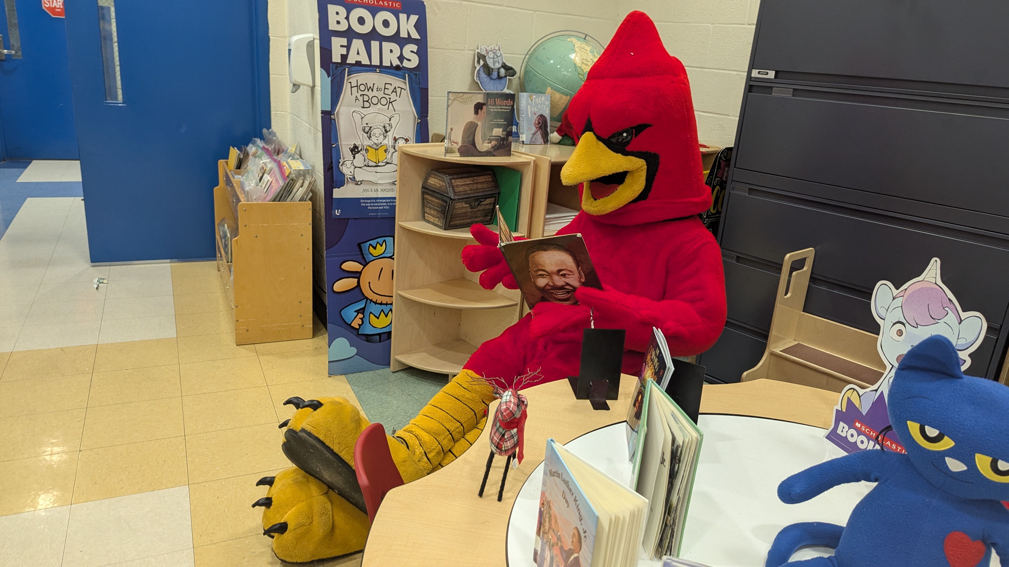 The York Cardinal mascot reads to students at a local school.